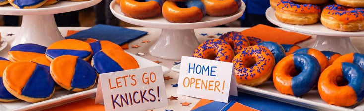 Blue and orange donuts and cookies on cake stands with Let's Go Knicks and Home Opener signs